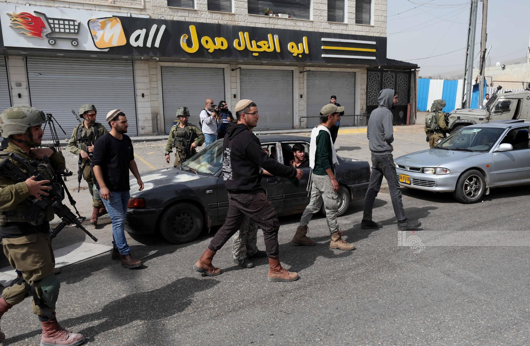 أرشيف "وفا"- مستعمرون يعربدون في بلدة حوارة جنوب نابلس، بحماية قوات الاحتلال الإسرائيلي